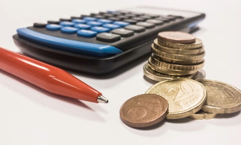 na stolu stoji hemijska, kalkulator i novčići